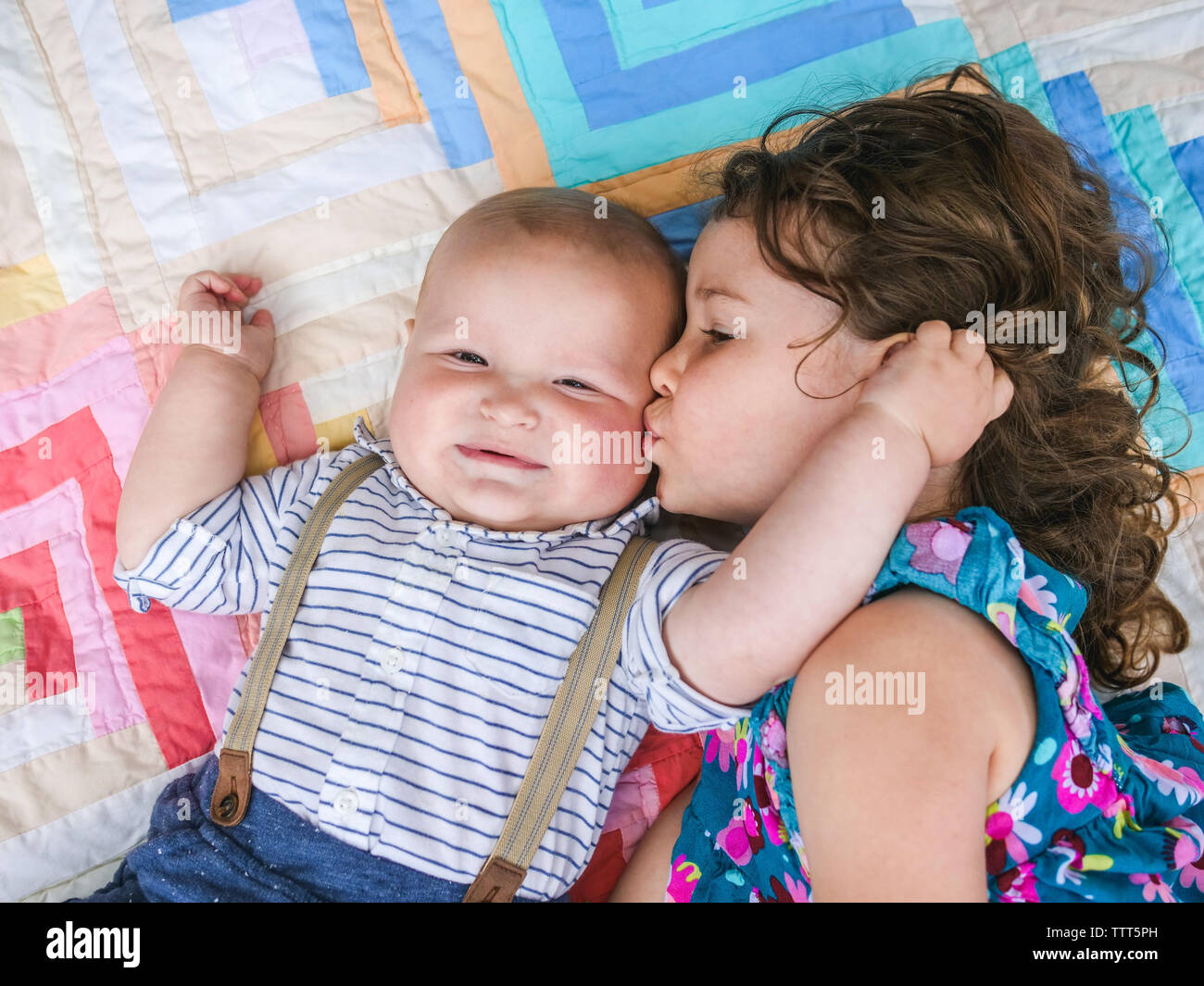 Top down ritratto della sorella di baciare il suo fratello più piccolo Foto Stock