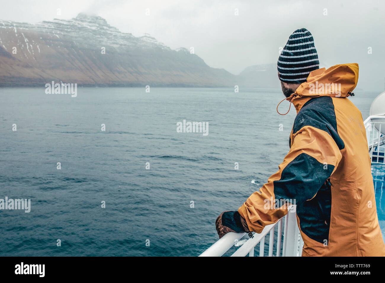 Vista laterale di un uomo guarda vista mentre si è in attesa della ringhiera in barca durante la stagione delle piogge Foto Stock