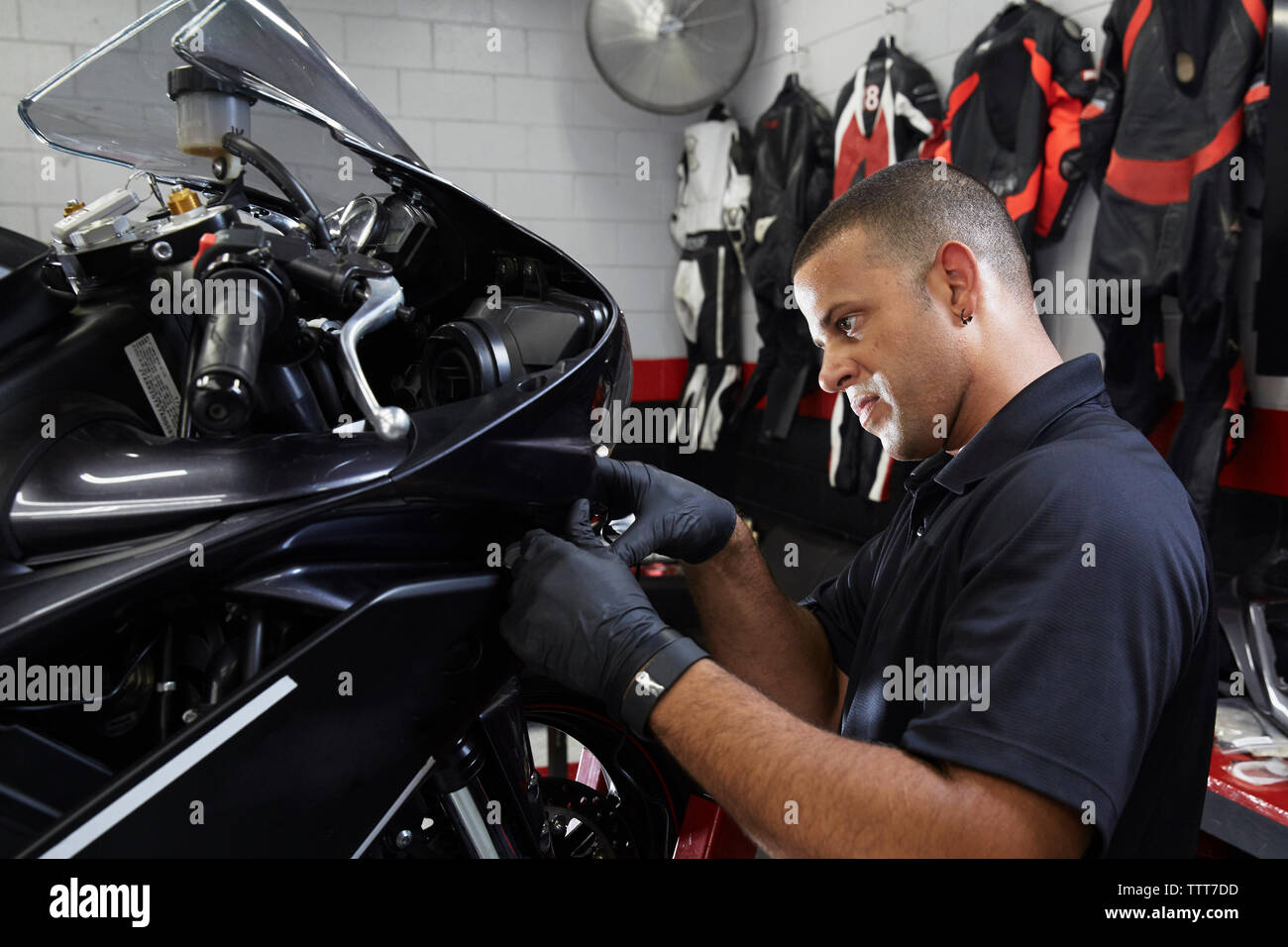 Fiducioso lavoratore esaminando la moto in officina Foto Stock