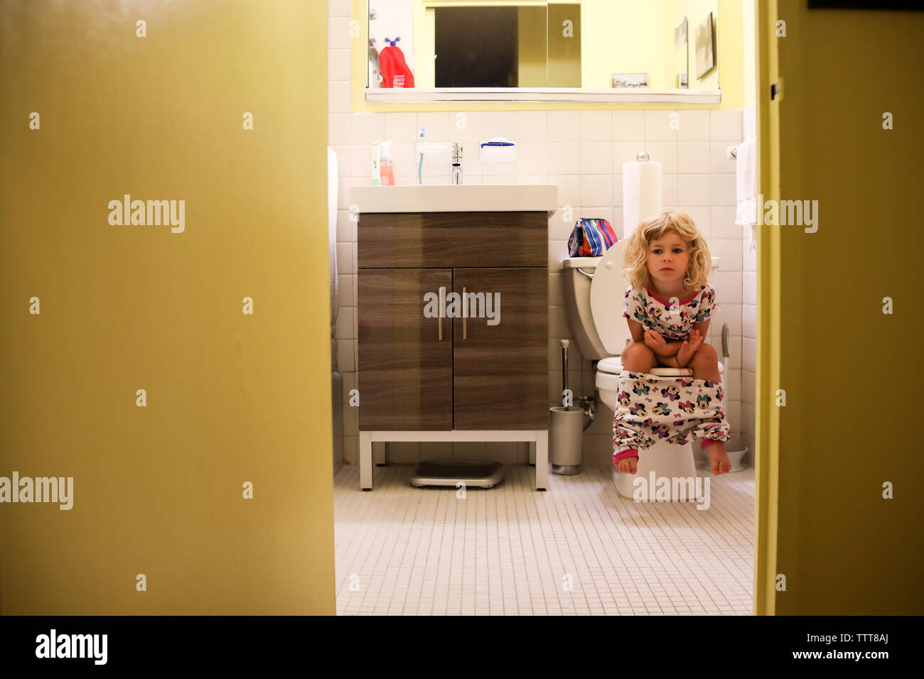 Bambina con wc al mattino con la testata Foto Stock