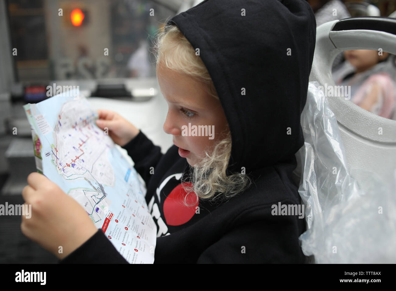 Ragazza guardando la mappa della città di new york indossando felpa con cappuccio Felpa Foto Stock