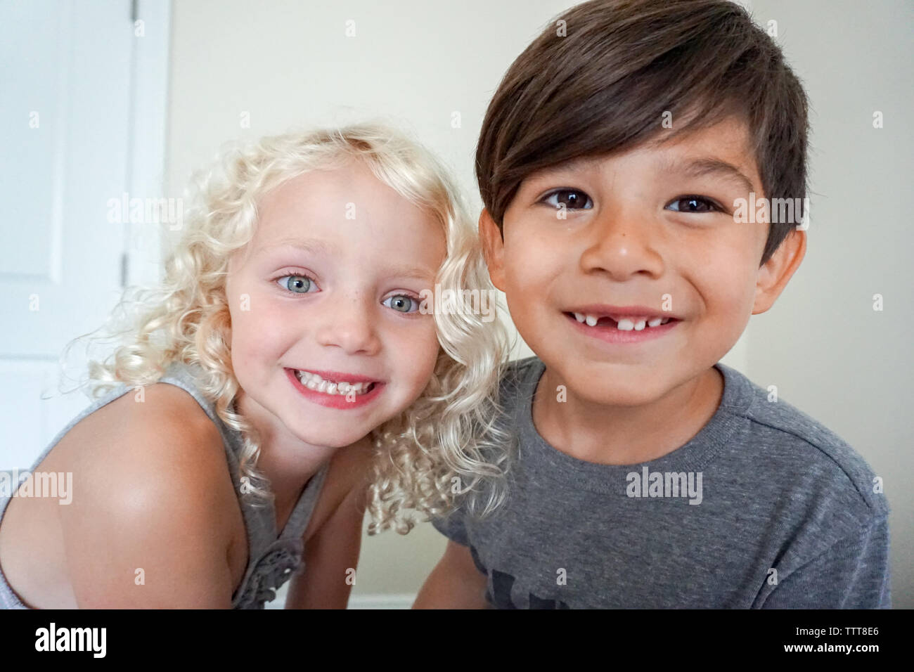 Un ragazzo e una ragazza fissando in telecamera closeup sorridente Foto Stock