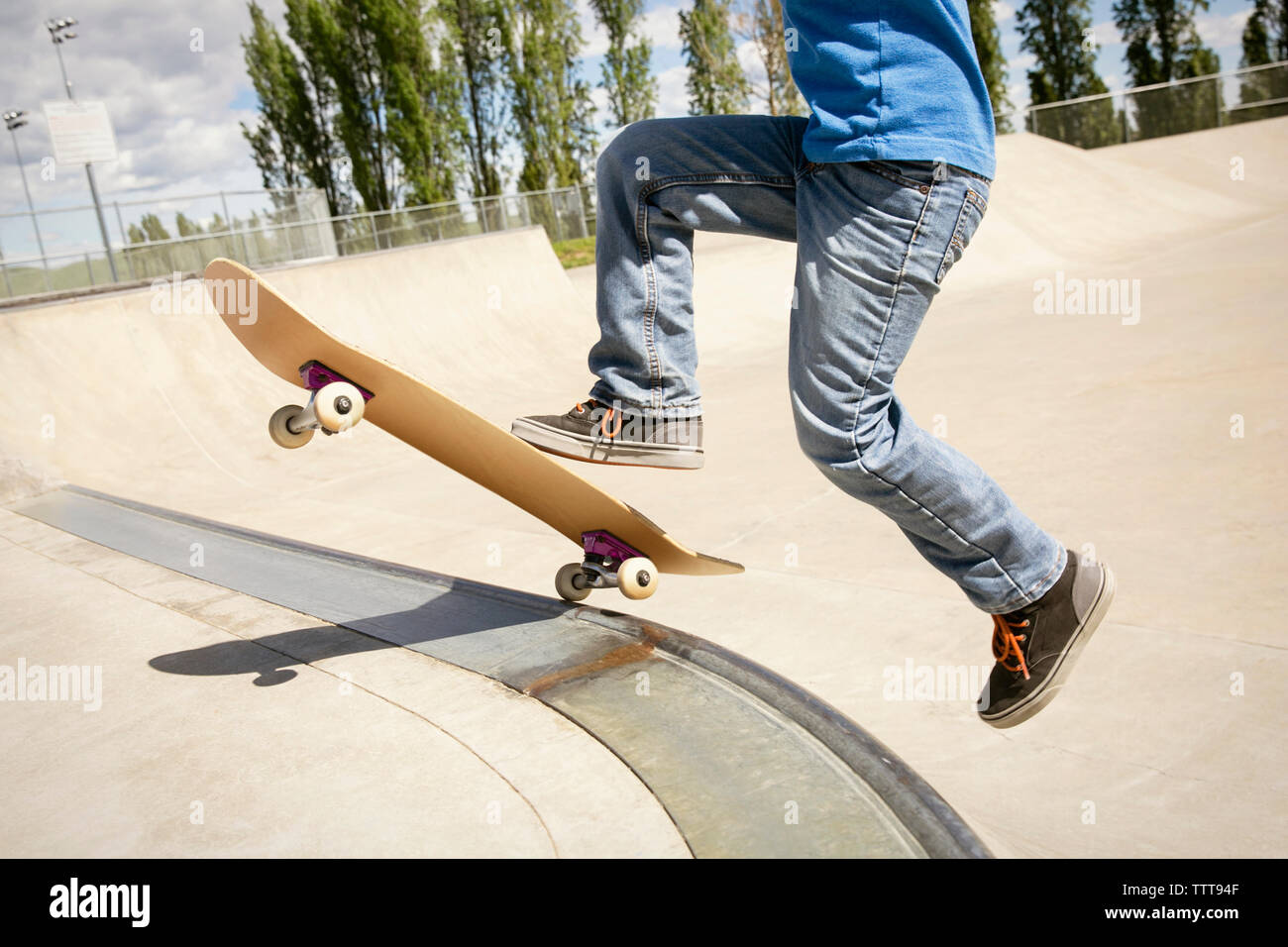 Sezione bassa del ragazzo lo skateboard sulla rampa Foto Stock