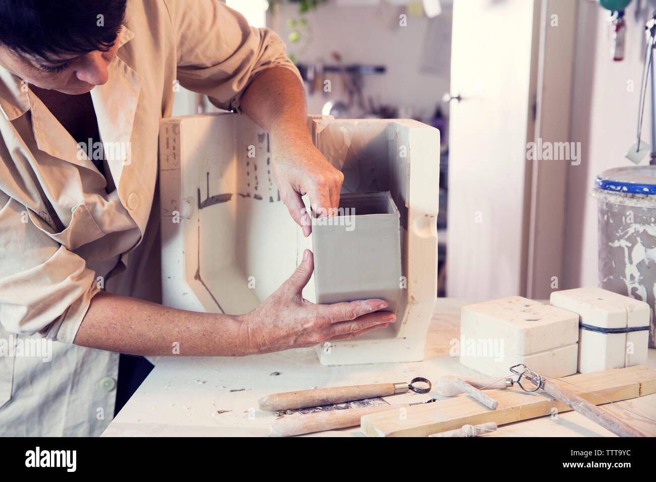 Donna che fa il box di argilla in officina Foto Stock