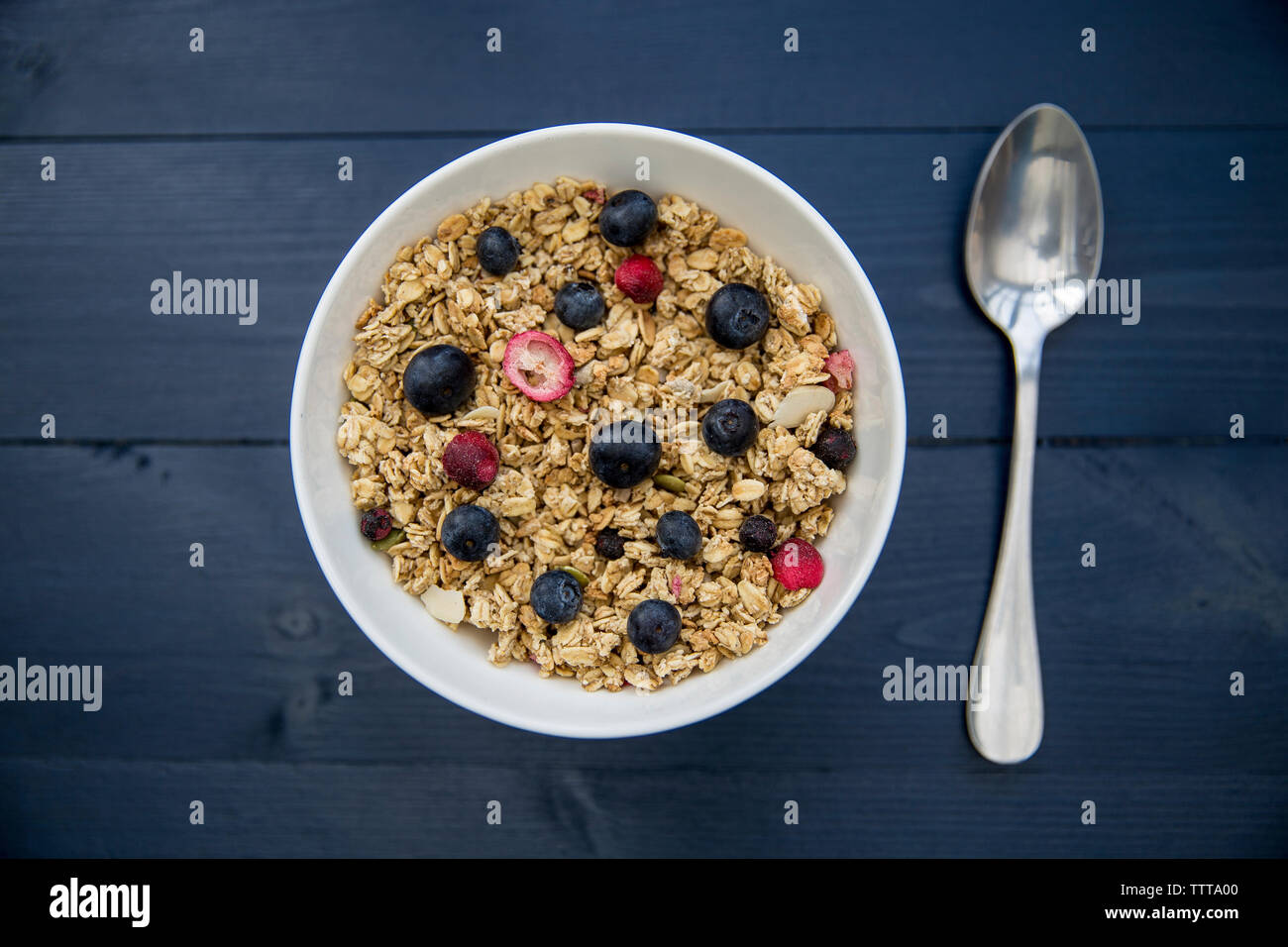Vista aerea di cereali per la prima colazione è servita nella ciotola con il cucchiaio sul tavolo di legno Foto Stock