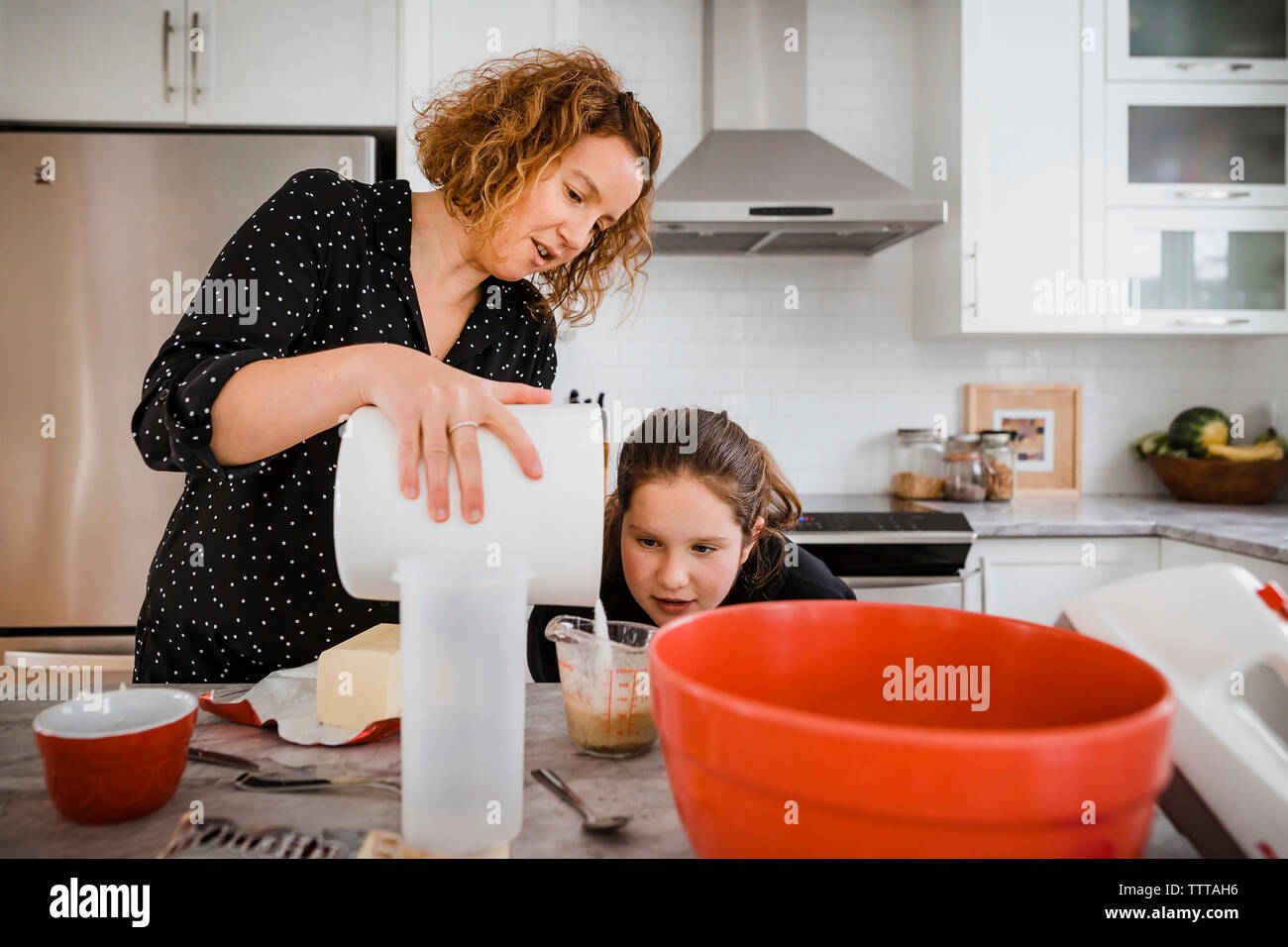 Madre figlia di insegnamento di cuoco in cucina a casa Foto Stock