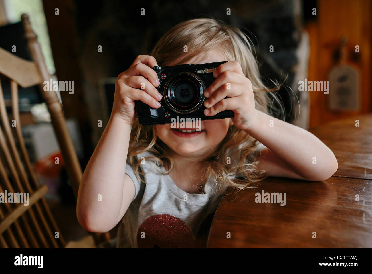 Il toddler girl imparare a scattare foto con una fotocamera Foto Stock