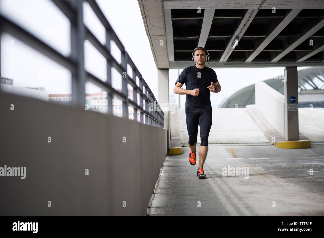 Determinato atleta maschio in esecuzione in parcheggio Foto Stock