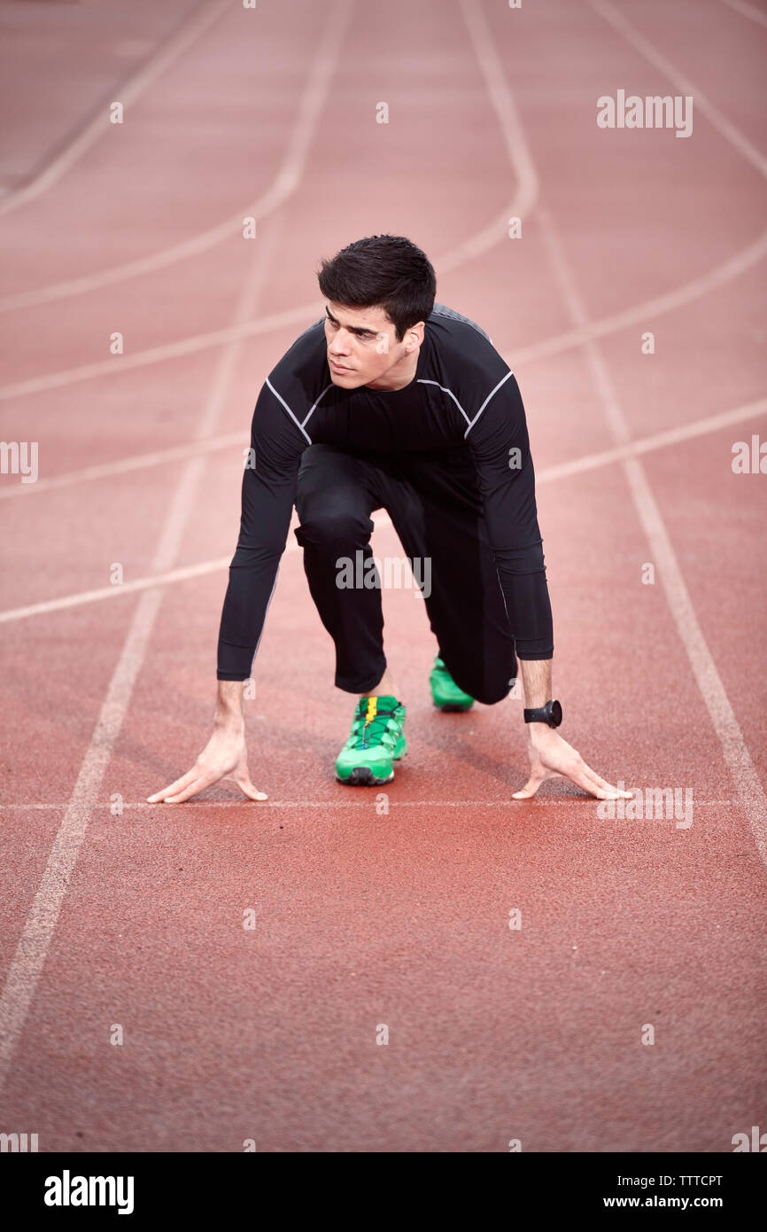 Angolo di alta vista di atleta maschio in linea di partenza Foto Stock