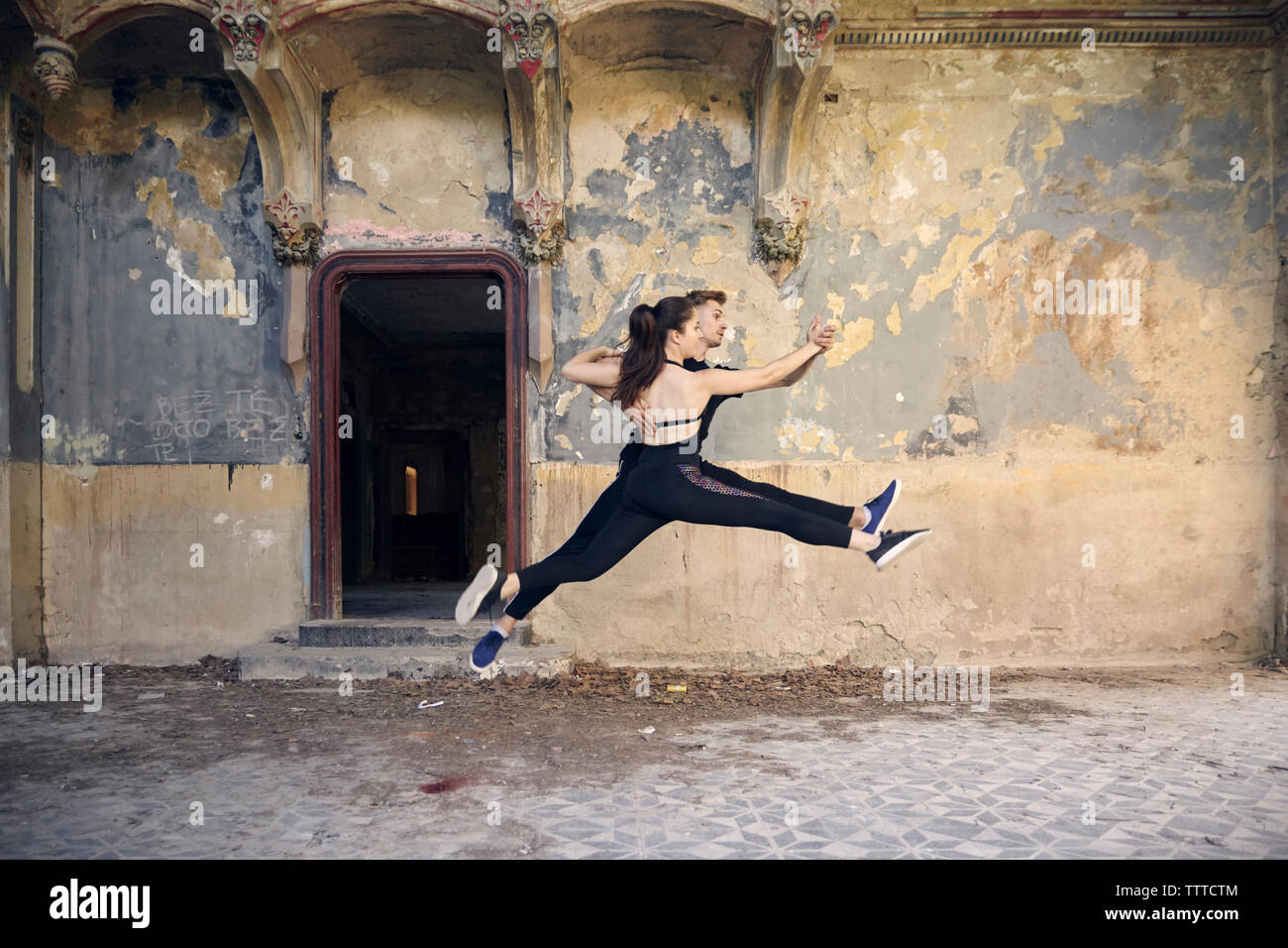 Ballerini saltando mentre ballare insieme nel vecchio edificio Foto Stock
