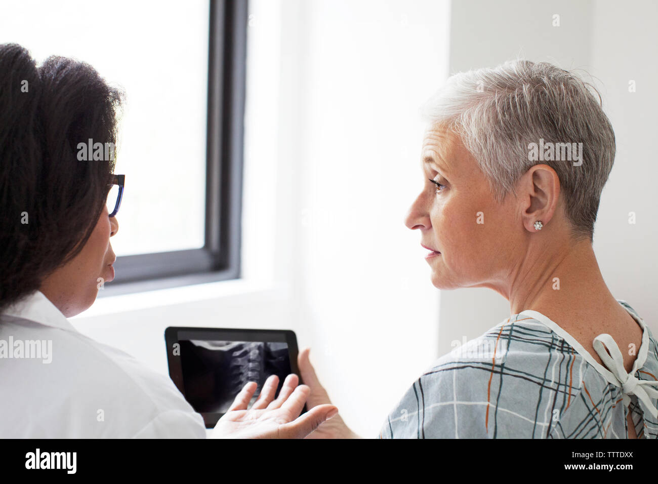 Medico donna a discutere di immagine a raggi X con il paziente in ospedale Foto Stock