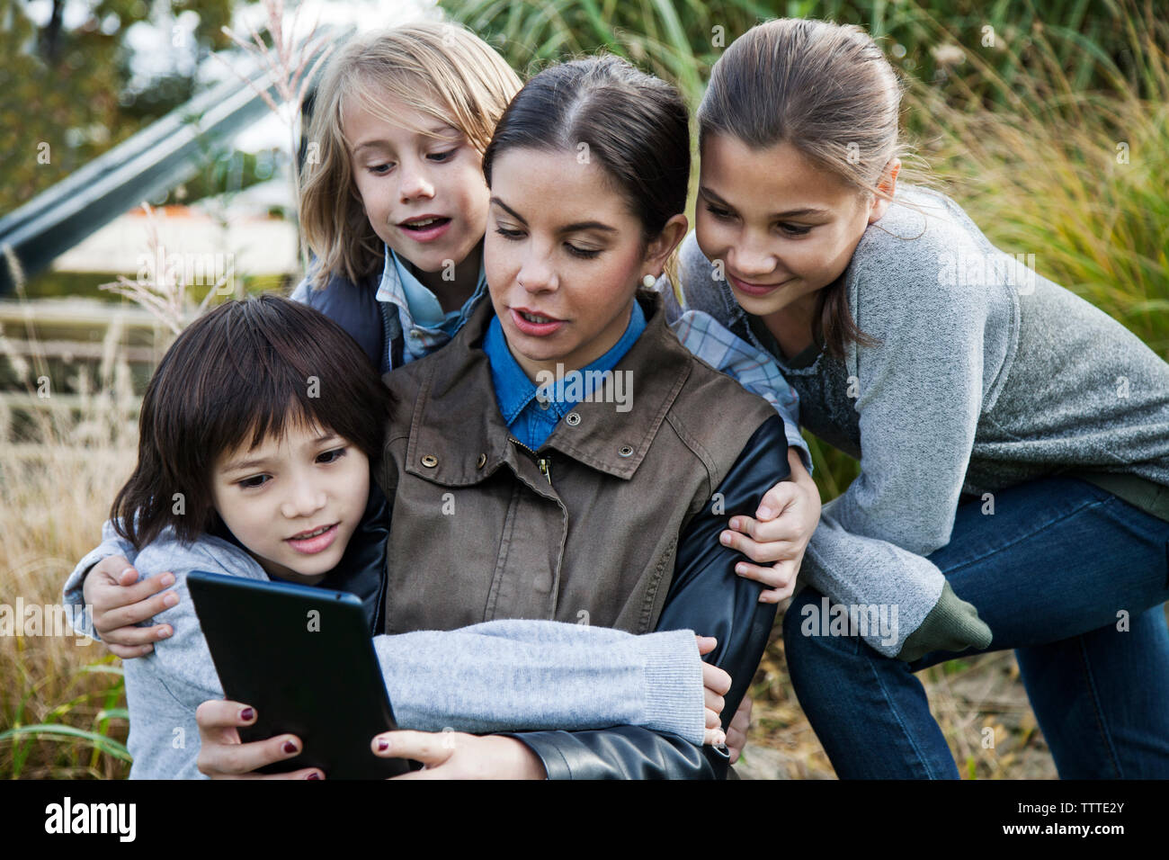 Insegnante che mostra computer tablet a scuola i bambini durante la gita Foto Stock