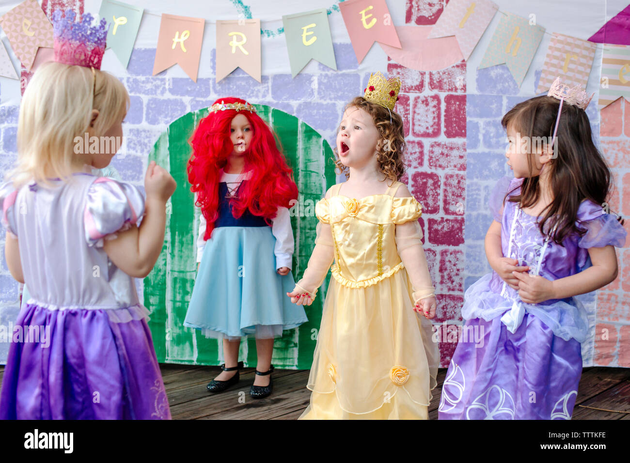 Giocoso ragazze contro la pittura del castello durante la principessa party Foto Stock