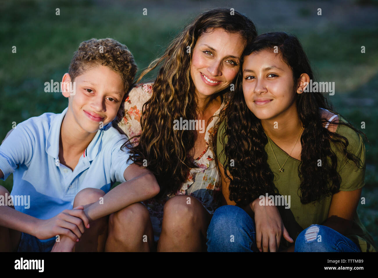 Ritratto di felice madre con bambini seduti in posizione di parcheggio Foto Stock