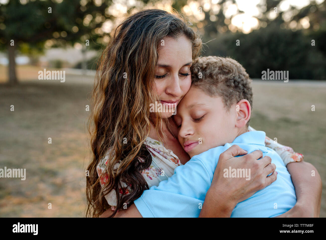 Amorevole Madre e Figlio con gli occhi chiusi abbracciando in posizione di parcheggio Foto Stock
