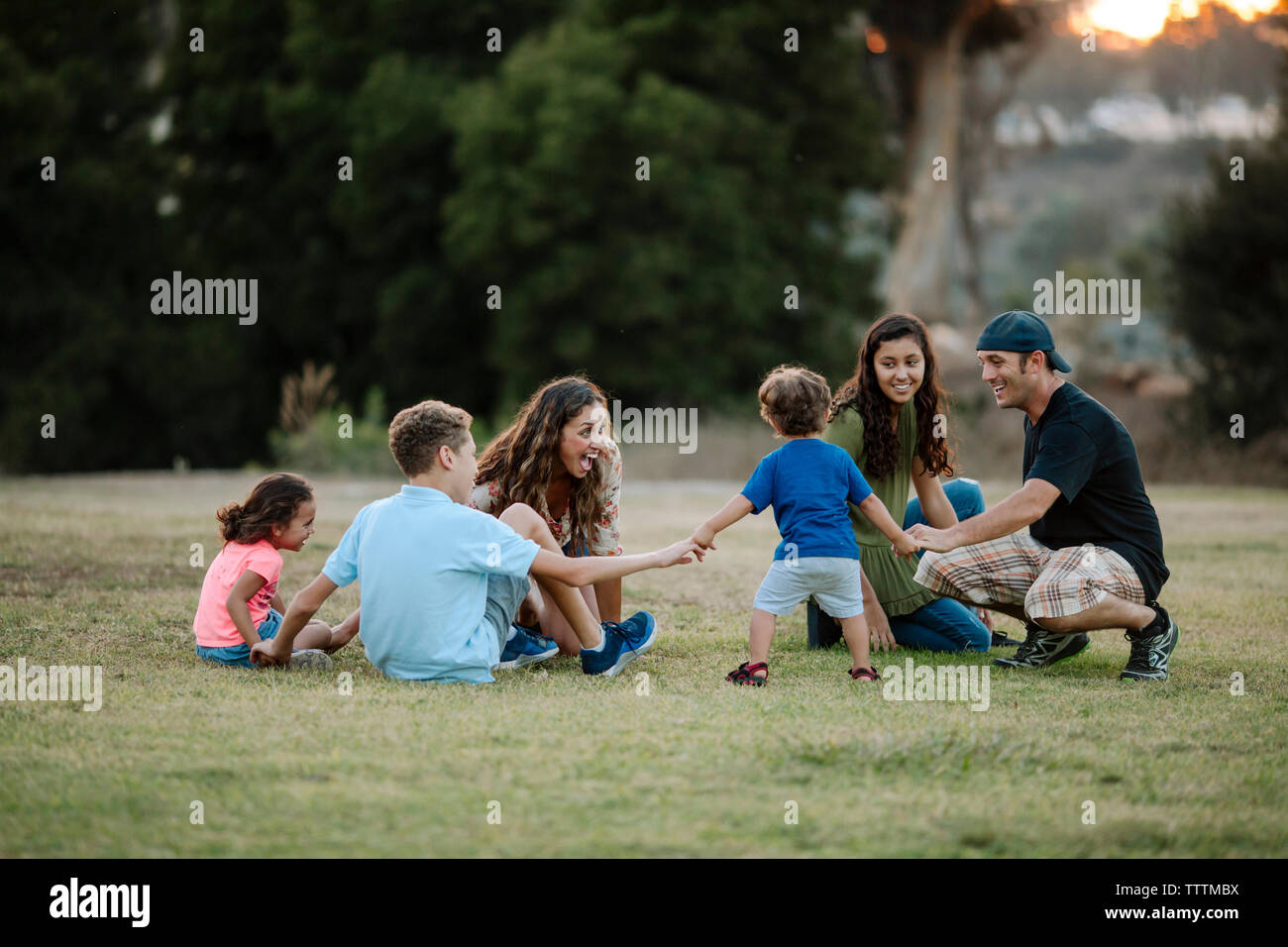 Famiglia allegra la riproduzione ad anello attorno al Rosy a park Foto Stock