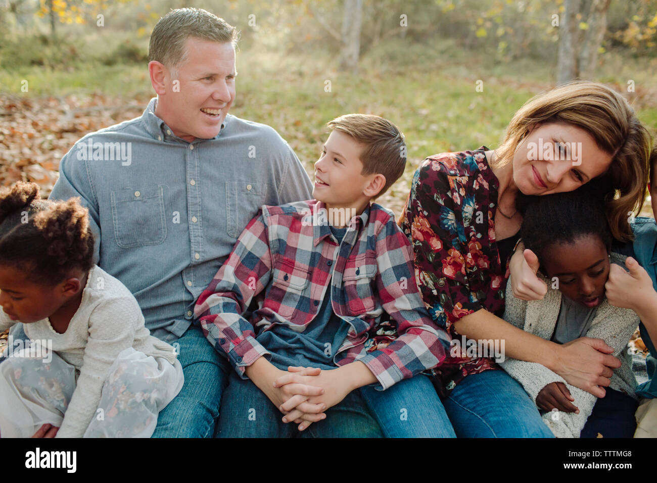 La famiglia felice seduto sul campo al park Foto Stock