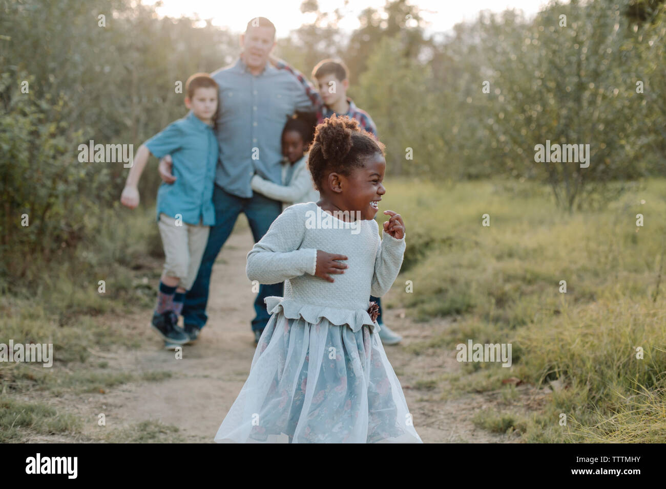 Bambini allegri con padre in campo al park Foto Stock