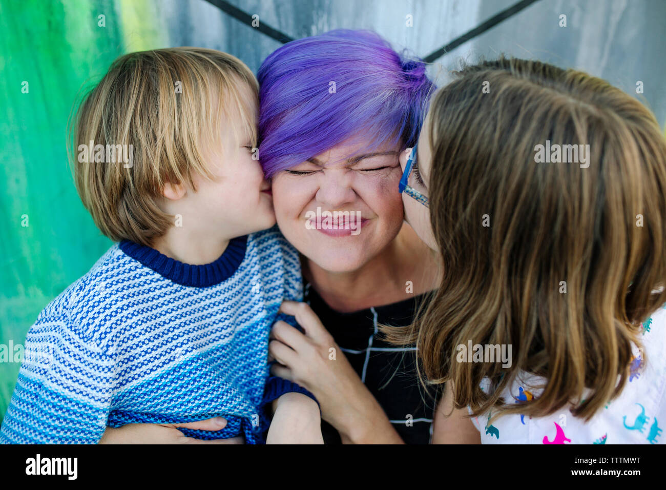 Dei bambini felici kissing madre presso il cafe Foto Stock
