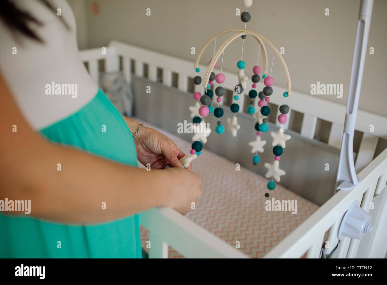 Sezione mediana della donna incinta azienda mobili pensili oltre il Presepe in casa Foto Stock
