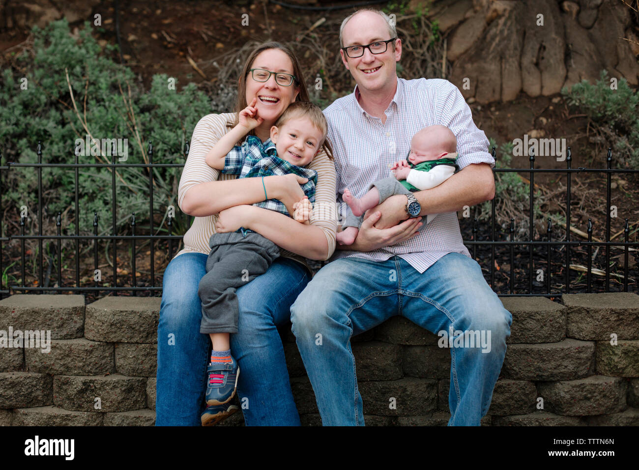 Ritratto di famiglia felice con pelo neonato bimbo seduto in posizione di parcheggio Foto Stock