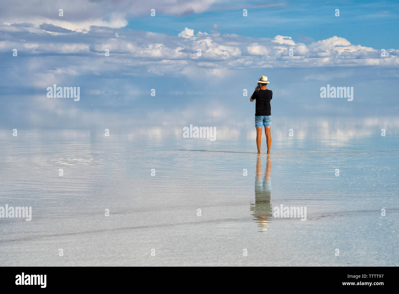 Tourist sulla superficie riflessa della distesa di sale, Salar de Uyuni, dipartimento di Potosi, Bolivia Foto Stock
