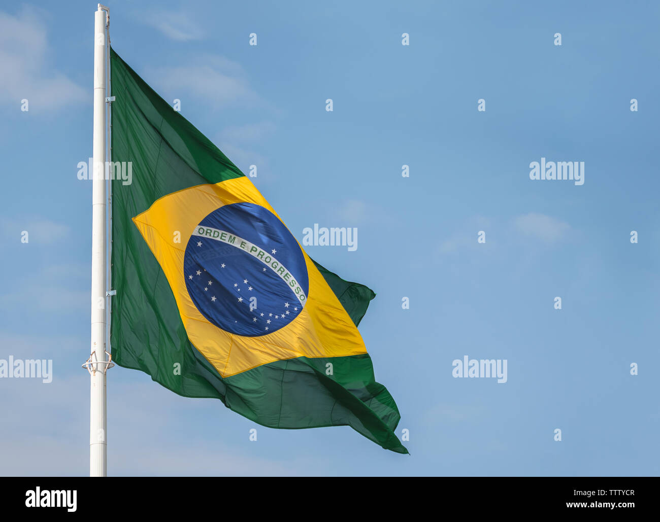 Bandiera Brasile sventolano al vento contro il cielo blu Foto Stock
