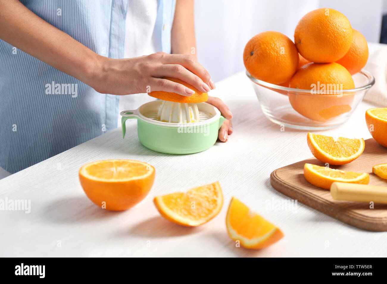 Mani femminili spremendo il succo d'arancia, primo piano Foto Stock