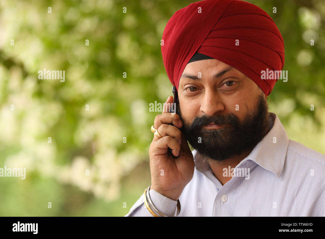 Indiano uomo sikh a parlare su un telefono mobile Foto Stock