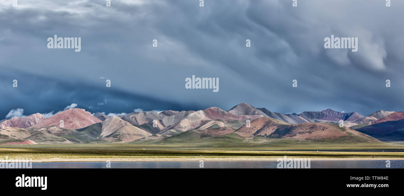 La gamma della montagna vicino a Nam Tso Lake, il Tibet (Cina, Asia). Nuvole nel cielo. Una tempesta potrebbe essere presto disponibile. Montagne colorate. Drammatico, mozzafiato. Foto Stock