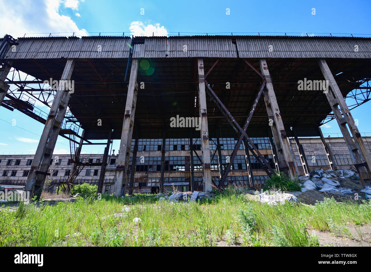 Vista di una fabbrica abbandonata, di un magazzino in una zona industriale di giorno. Fotografia orizzontale Foto Stock