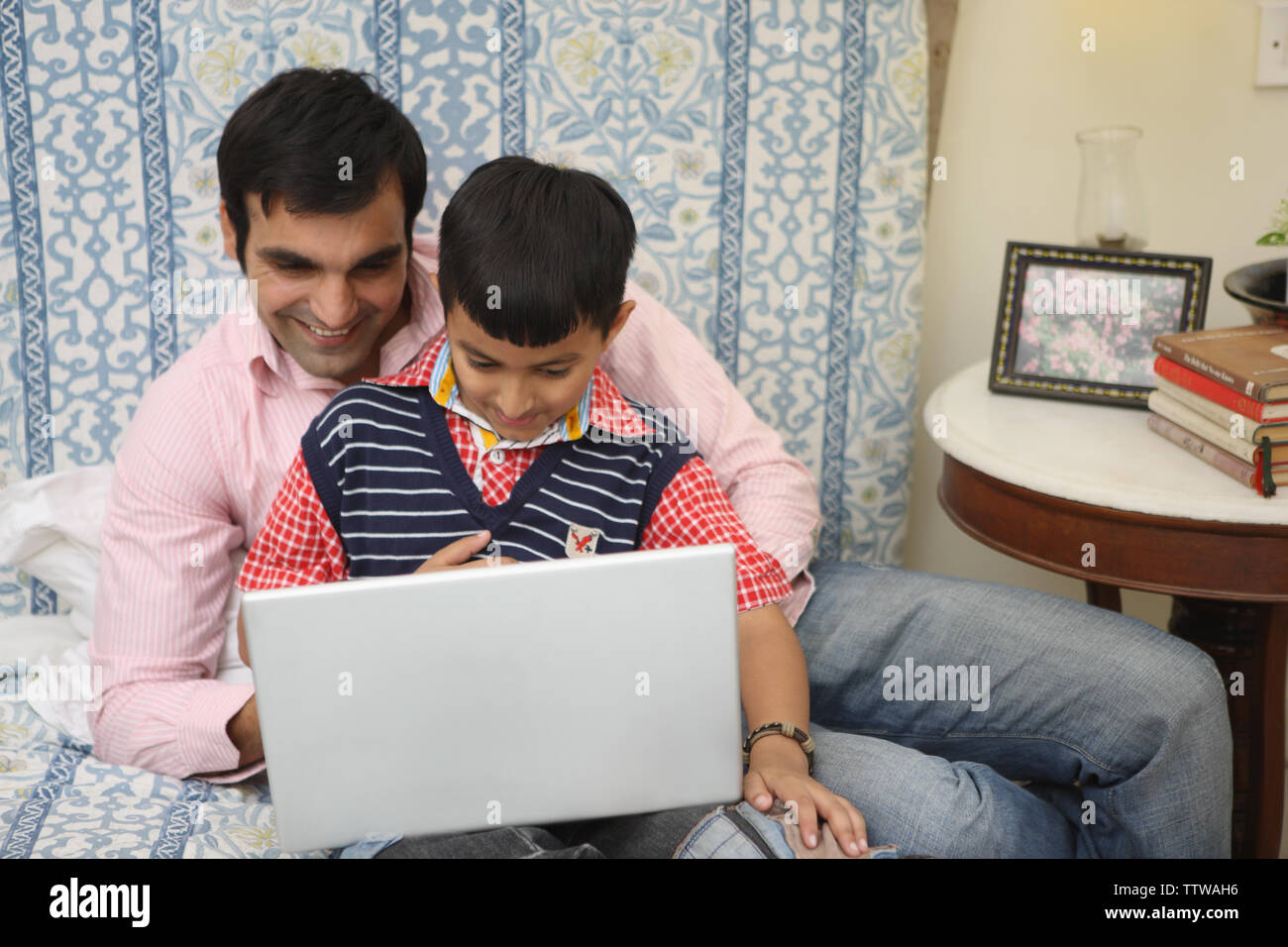 L'uomo con il suo figlio al lavoro su un notebook Foto Stock