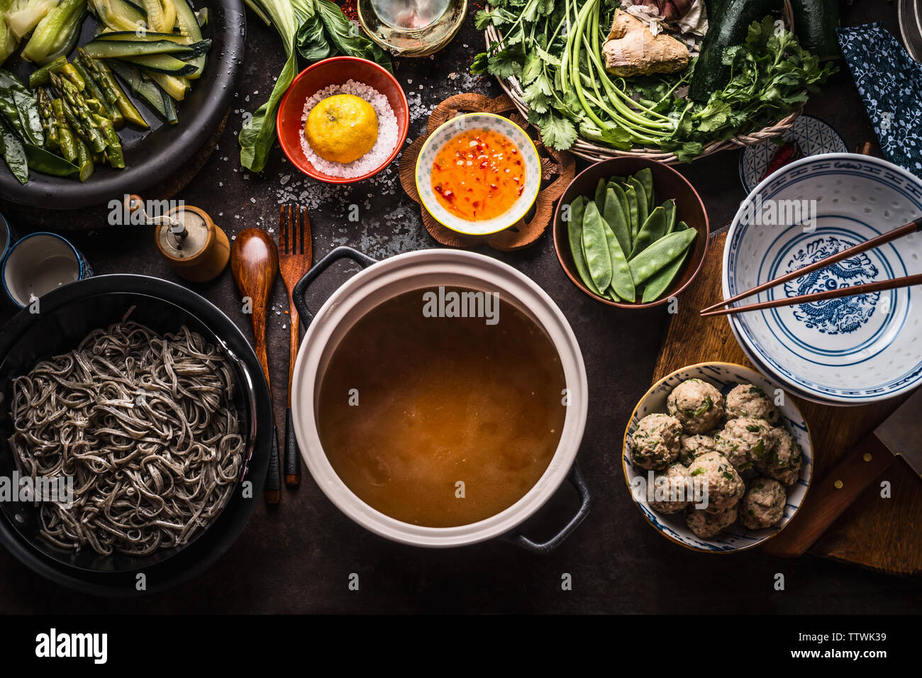 Varie cibo asiatico ingredienti per gustare la sua pasta di soba soup attorno al recipiente di cottura con delizioso brodo di miso o stock sulla cucina rustica sfondo tabella, t Foto Stock