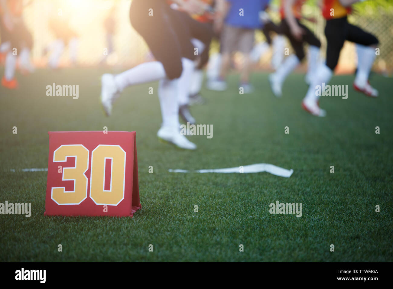 Foto del campo di calcio con il numero trenta in esecuzione i giocatori di calcio su sfondo sfocato sul giorno di estate.effetto Lensflare Foto Stock