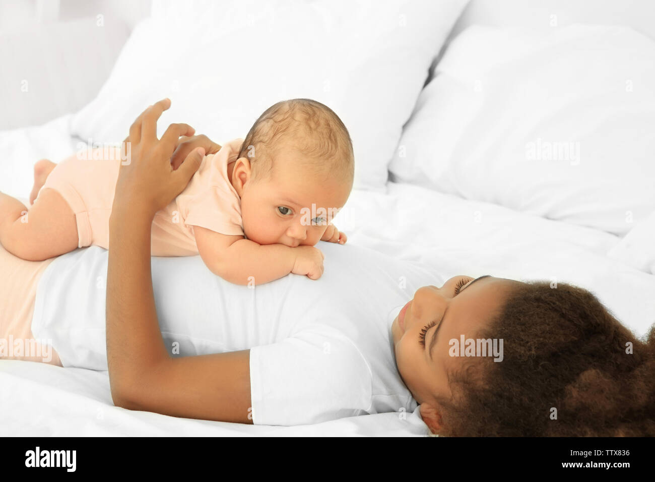 Carino il bambino e la sorella maggiore sul letto Foto Stock