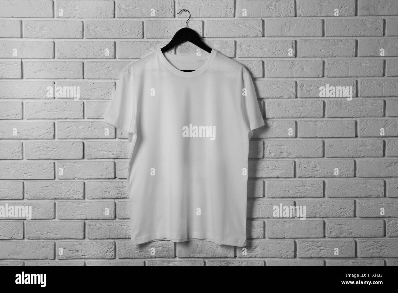 Blank t-shirt bianco contro un muro di mattoni Foto Stock