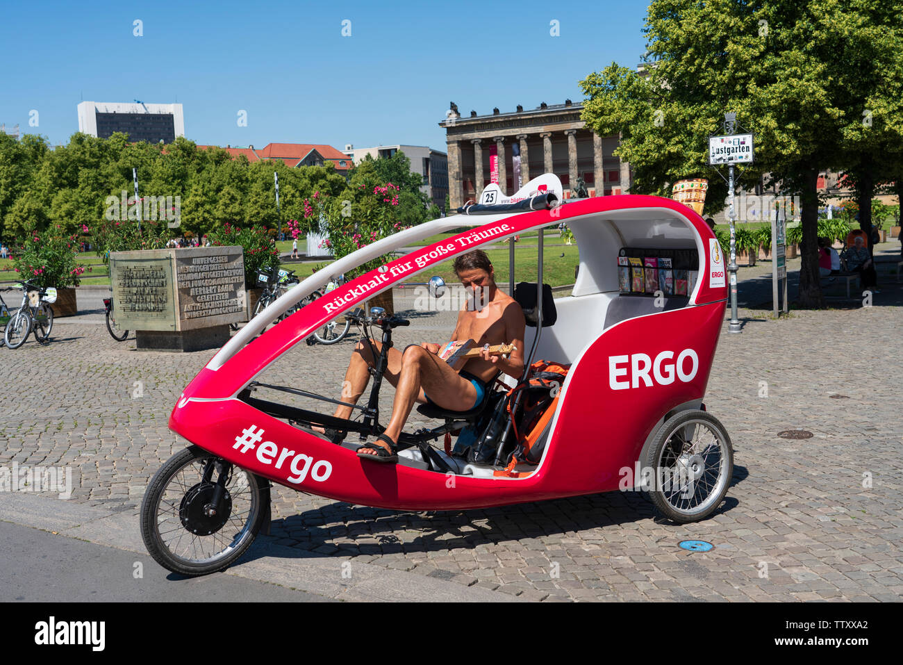 Guida turistica di triciclo a suonare la chitarra in attesa per i clienti a Mitte di Berlino, Germania Foto Stock