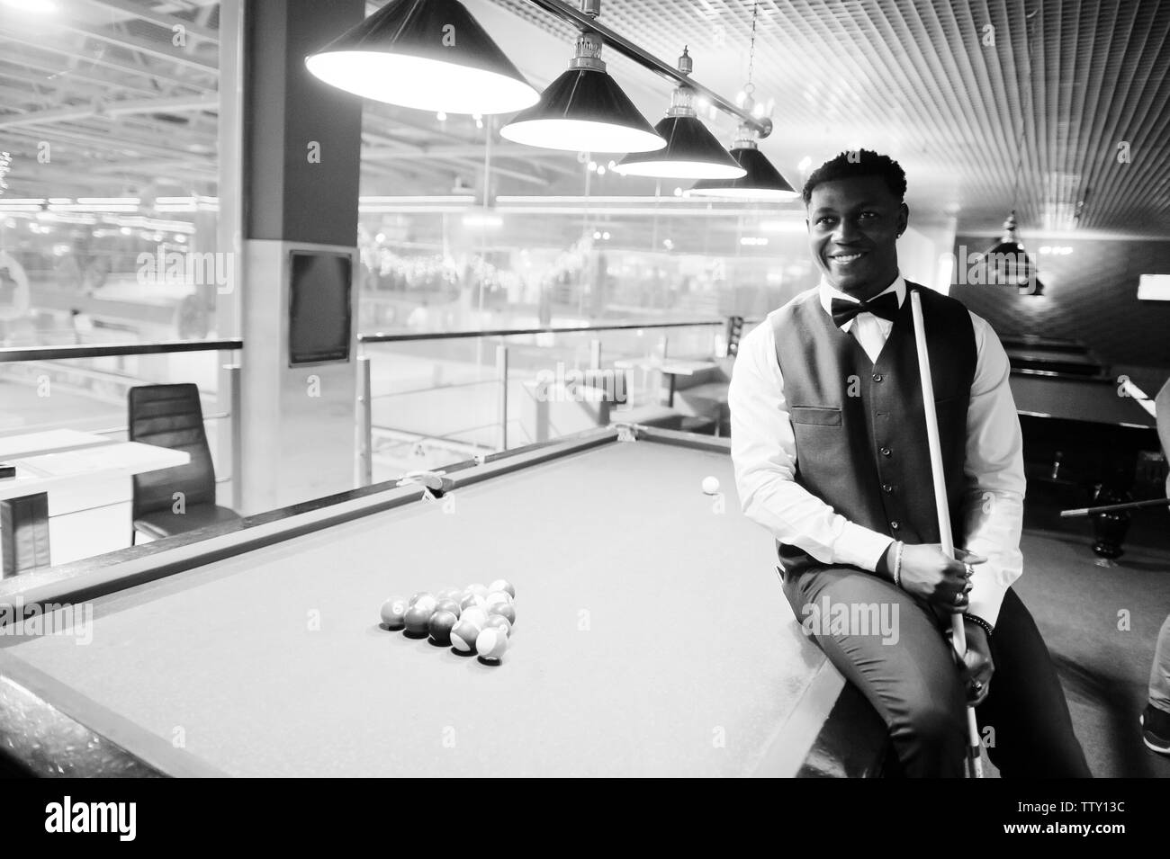 I giovani africani bello uomo che indossa una camicia bianca, Gilet nero e il filtro bow tie giocare biliardo Piscina. Foto Stock