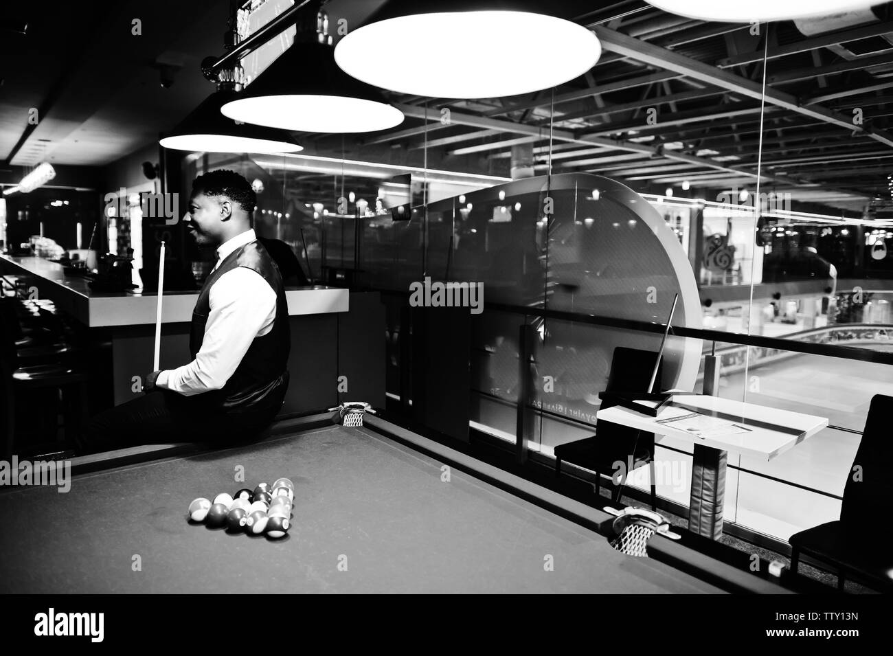 I giovani africani bello uomo che indossa una camicia bianca, Gilet nero e il filtro bow tie giocare biliardo Piscina. Foto Stock