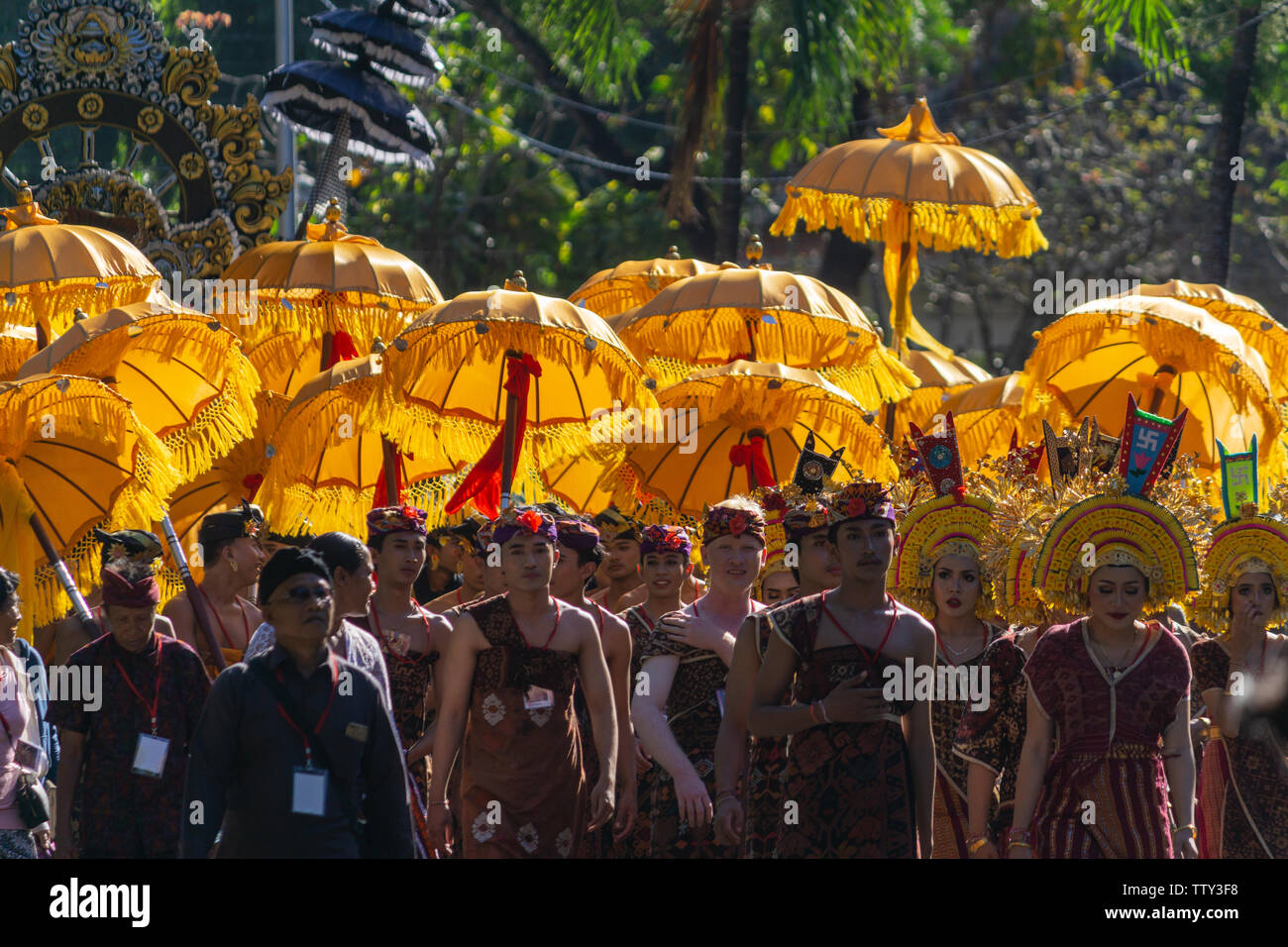 DENPASAR/INDONESIA-Giugno 15 2019: un gruppo di ballerini Balinesi in costumi etnici con tradizionale ombrelloni colorati sulla cerimonia Indù parade durante il templ Foto Stock