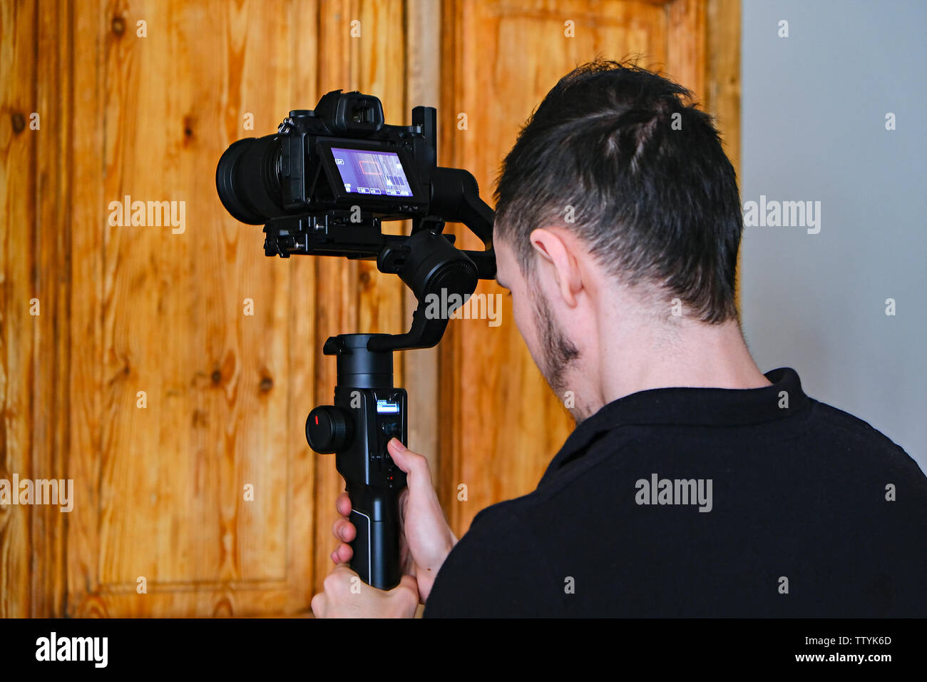 Videografo di una Steadicam nelle mani. Un giovane uomo applica le impostazioni della steadicam Foto Stock