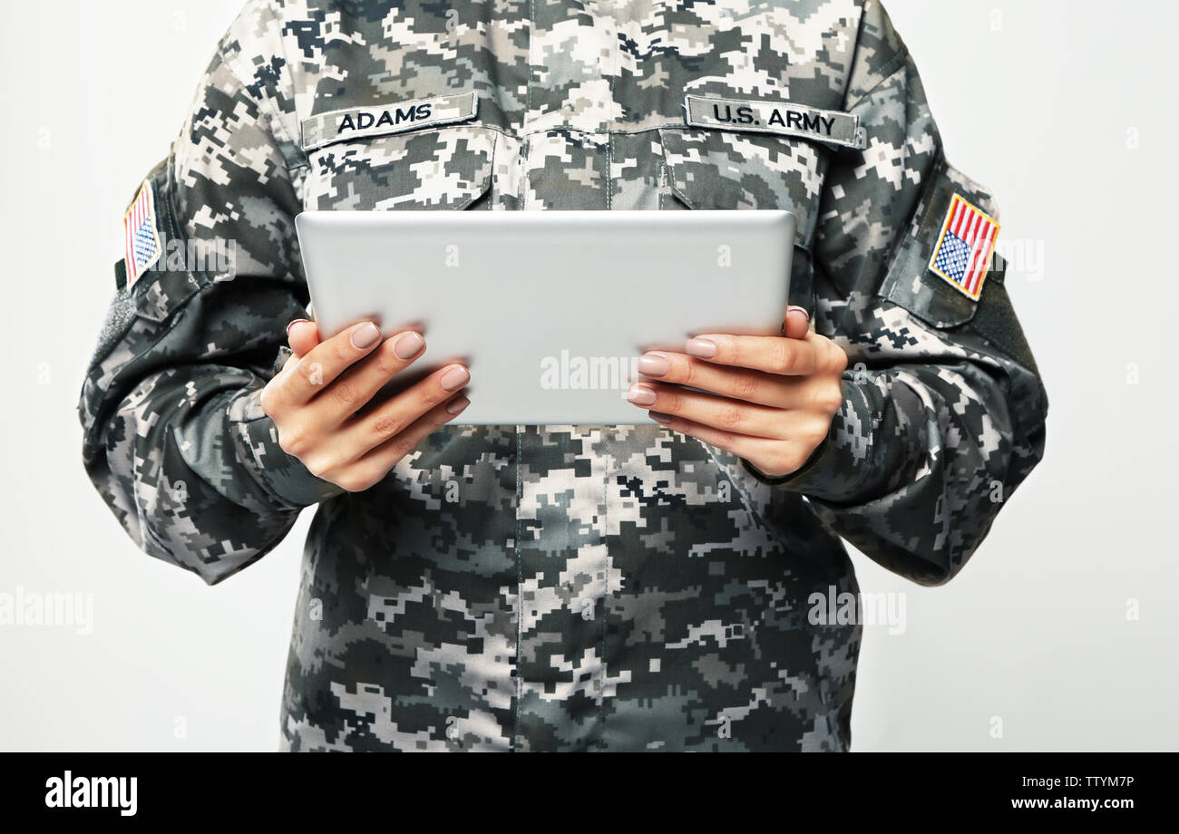 Soldato femmina con tablet pc su uno sfondo grigio, primo piano Foto Stock