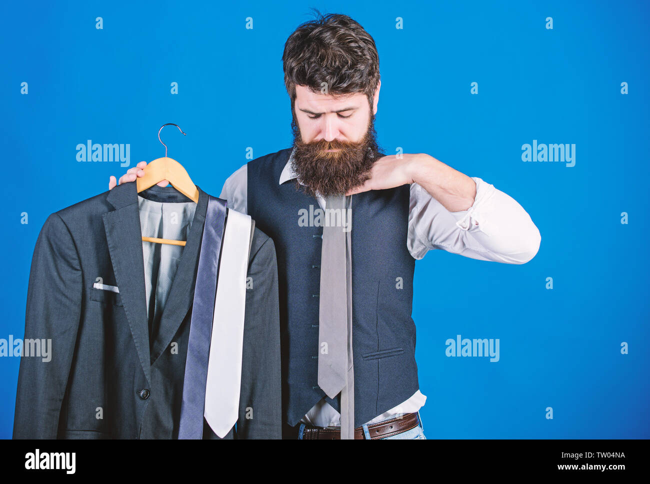 Abbinamento cravatta vestito. Uomo Barbuto hipster tenere cravatte e tuta  formale. Cravatta perfetta. Il concetto di shopping. Stylist consigli.  Difficoltà scegliendo cravatta. Shop assistant o stilista personale di  servizio Foto stock -