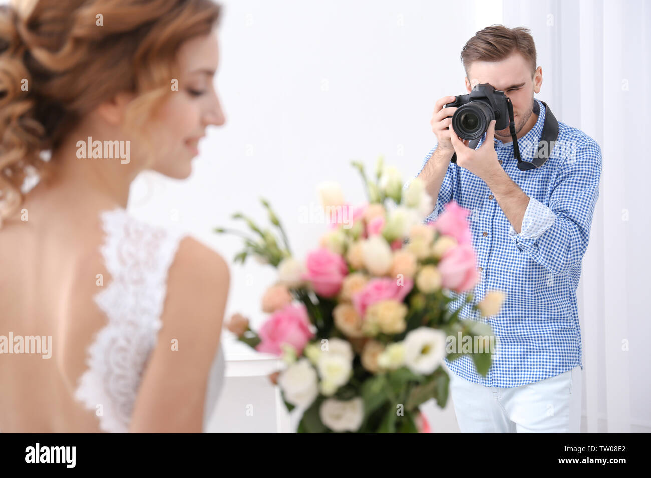 Fotografo Matrimonio prendendo foto di bella sposa in studio Foto Stock