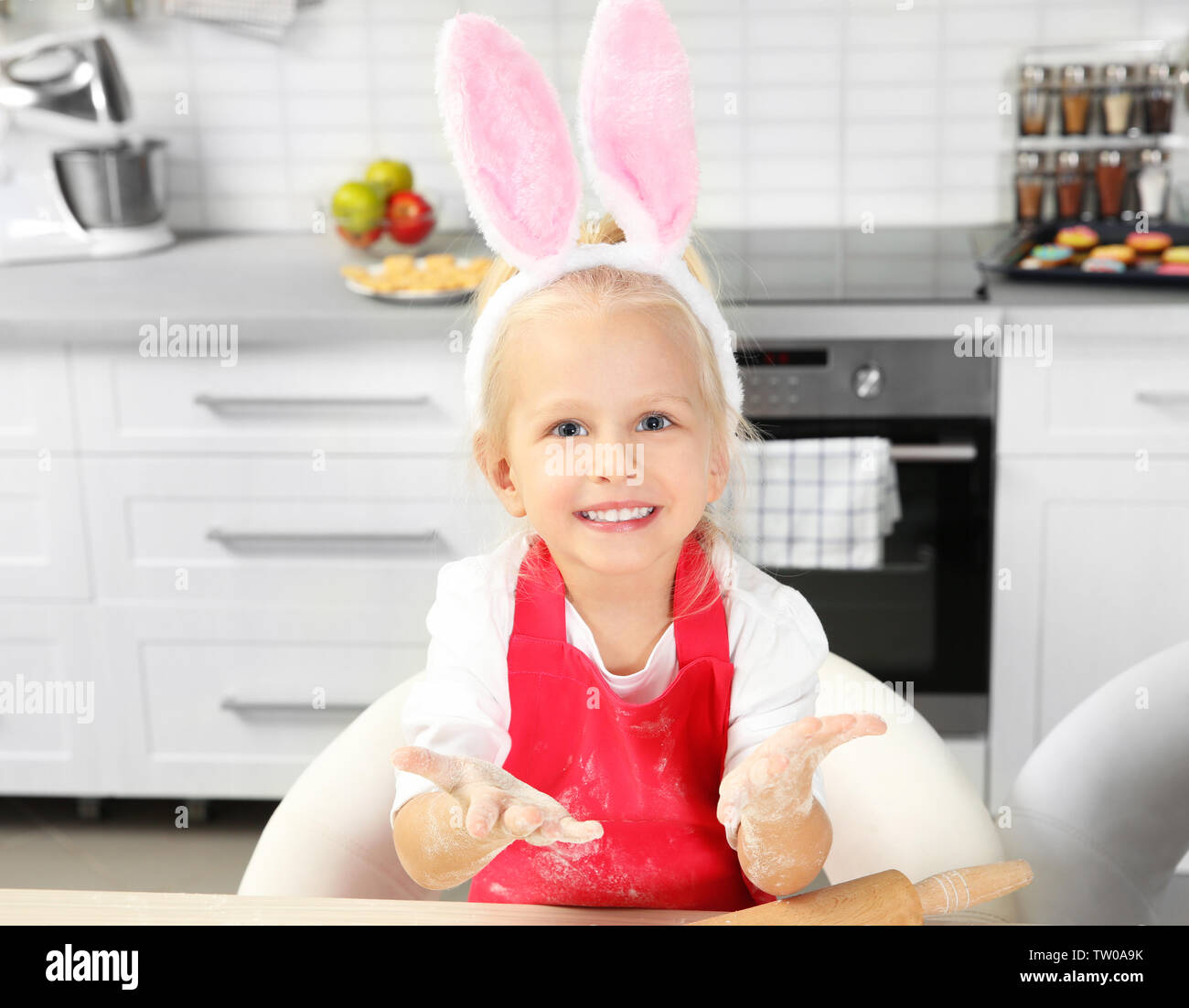 Carino bambina con le mani la farina in cucina Foto Stock