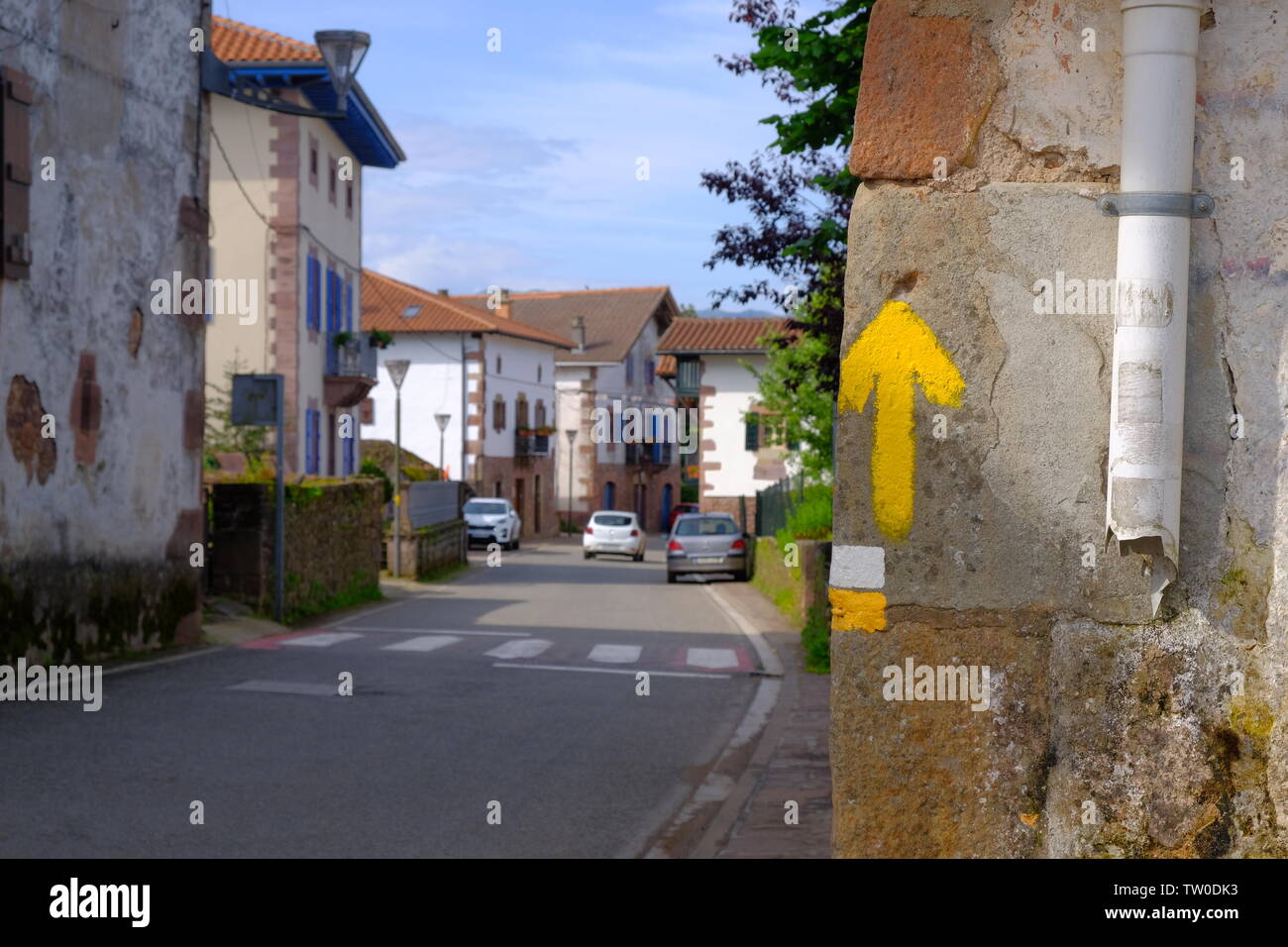 Dipinto di giallo freccia su una casa in Spagna indicando il modo per escursionisti verso Santiago de Compostela e il modo di St-James Foto Stock
