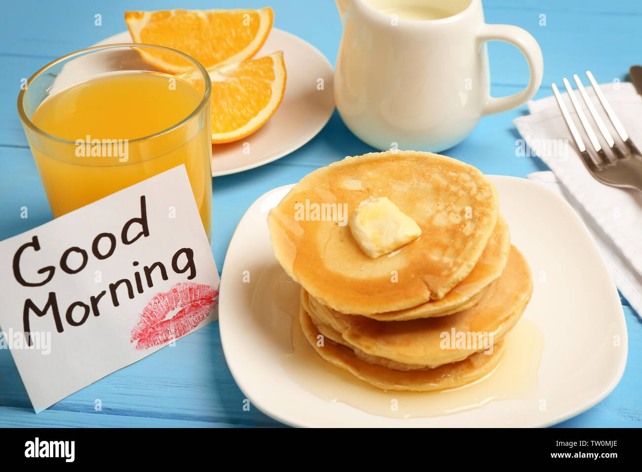 Una gustosa prima colazione e prendere nota di buona mattina sul tavolo da cucina Foto Stock