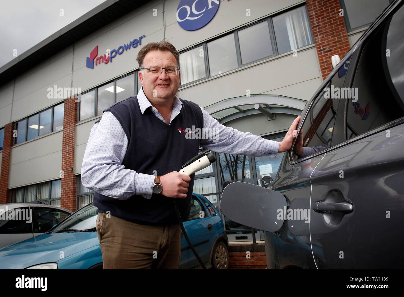 Ben Harrison, managing partner di mypower, il pannello solare azienda di installazione, che può ricaricare la sua Mitsubishi Outlander PHEV auto ibride, con elec Foto Stock