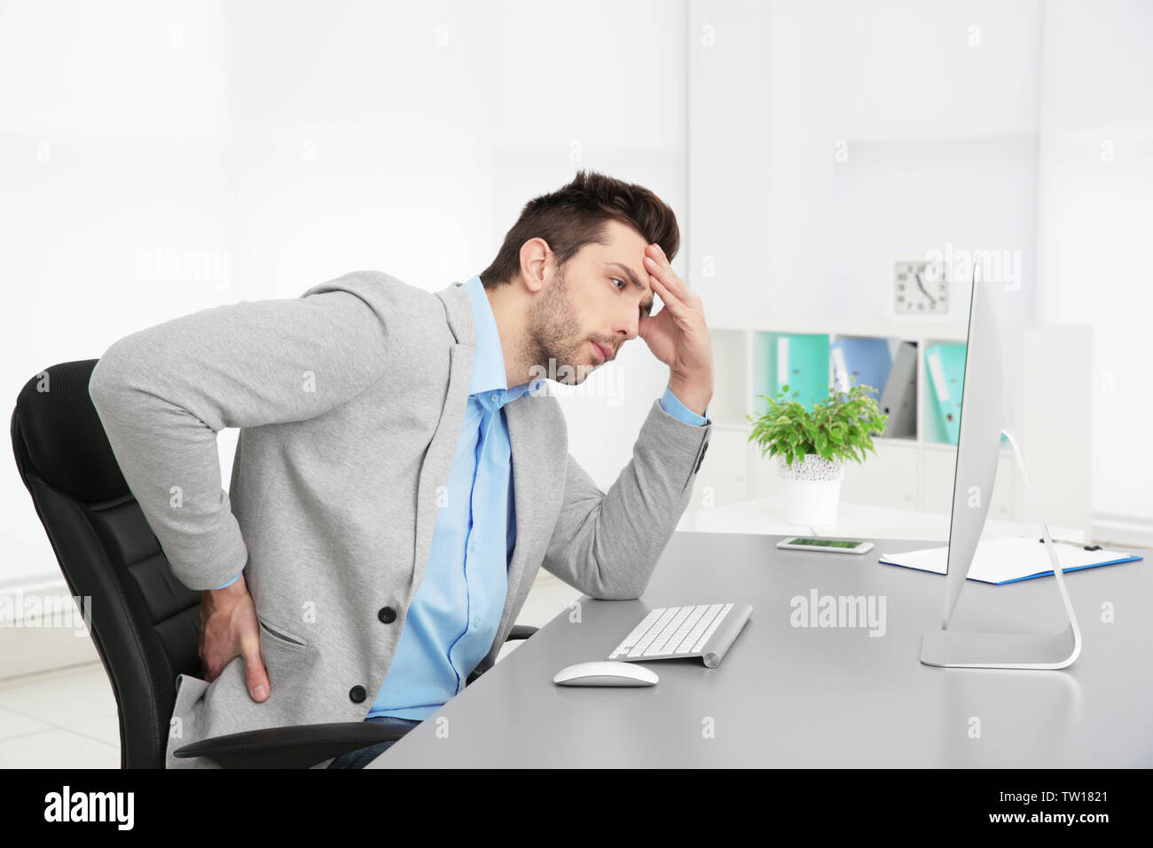 La possibilità di postura non corretta nozione. Uomo seduto al tavolo per ufficio Foto Stock