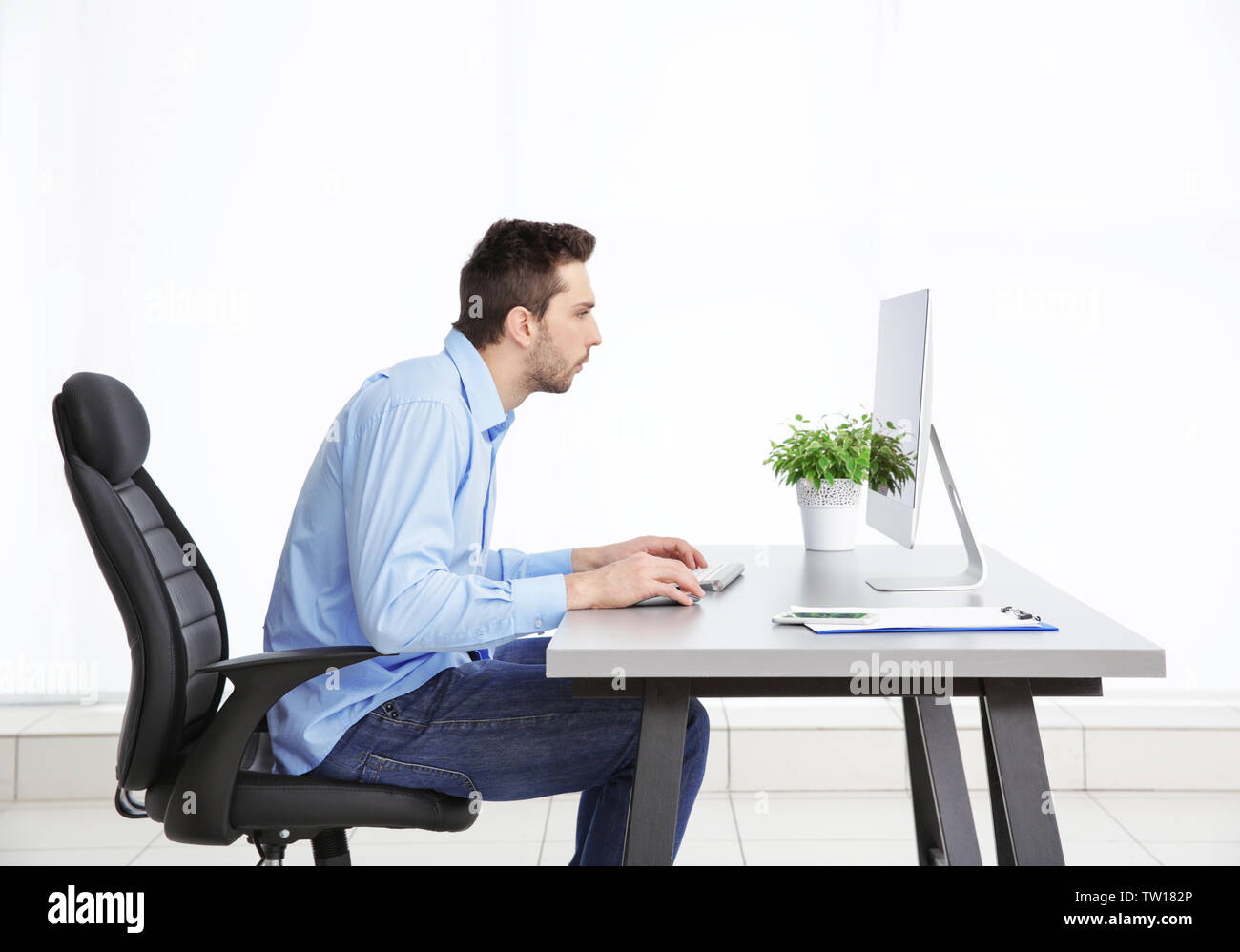 La possibilità di postura non corretta nozione. Uomo seduto al tavolo per ufficio Foto Stock